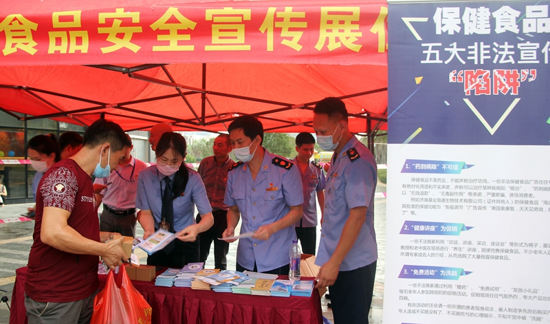 市场监管部门工作人员正向市民分发食安知识宣传手册，普及食品安全知识（区市场监管局供图）.JPG