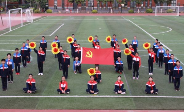 集美区杏东小学六年级学生与党旗合影