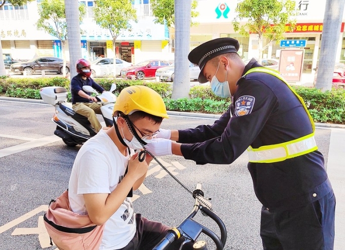 民警在执勤中帮助骑电动车市民戴头盔.jpg
