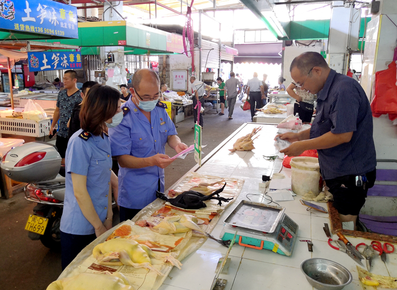 市场监管部门工作人员检查农贸市场白条禽经营摊位进货票据情况(区市场监管局供图).jpg