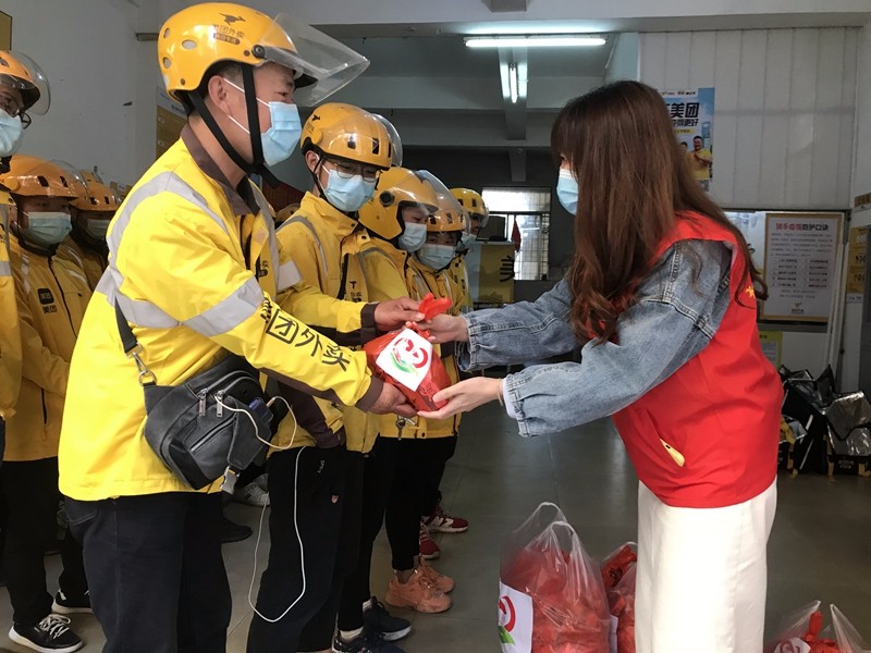 志愿者给外卖员送上牛奶面包等爱心礼包(杏林街道新时代文明实践所供图).jpg
