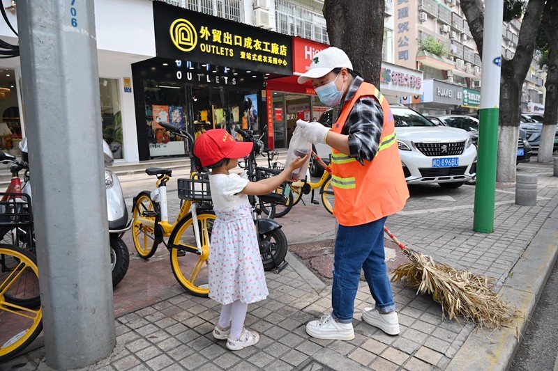 小志愿者给环卫工人送上柠檬茶（拍摄 冯立东）.JPG