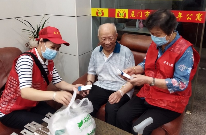 夕阳美志愿服务队老年志愿者为爱欣老年公寓的老人送药（诚毅志愿者联盟供图）.jpg