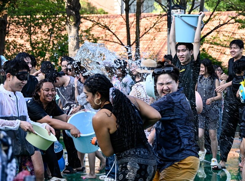 肤色各异的留学生们手持水盆、水桶、玩具水枪等工具，相互泼洒，传递节日的喜悦，表达美好祝福。（林志杰摄影） (42 - 54).jpg
